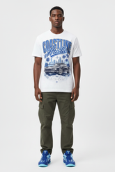 Male model wearing Coastline Hustle graphic tee with Nike Zoom Kobe 5 Protro X-Ray sneakers